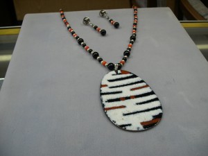1259-  This is a one of a kind enameled large drop necklace in white/black/red.  The beads are black onyx, red plastic and sterling silver.  Can be worn with for casual or dress. A must see!!